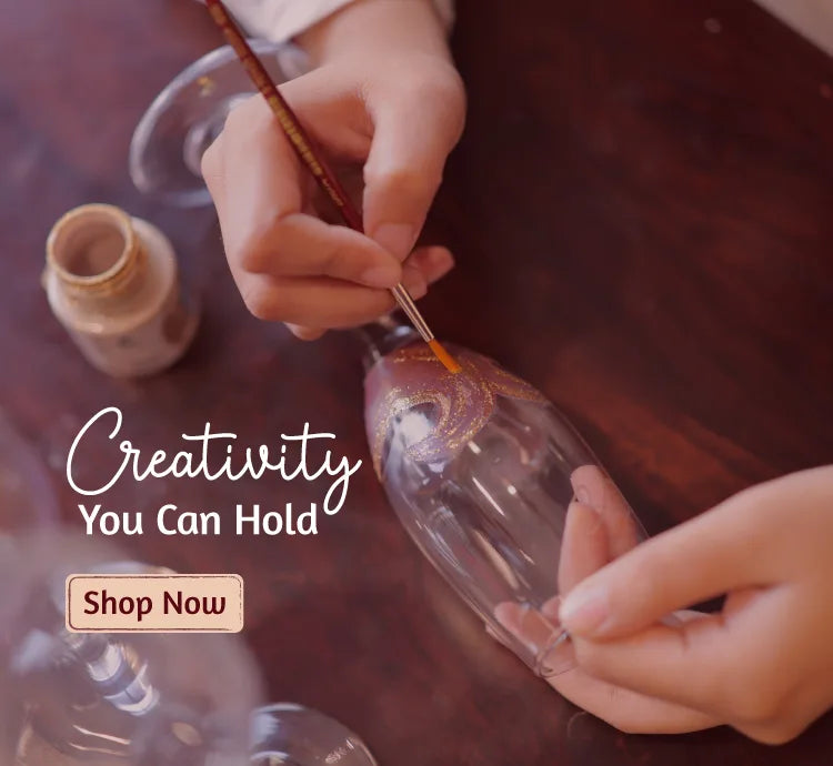 Artist hand painting a decorative champagne glass for Ekeha handcrafted glass collection