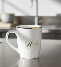 White ceramic mug with gold rim and elegant monogram initials AG printed on front