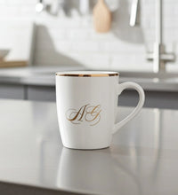White ceramic mug with gold rim and elegant monogram initials AG printed on front